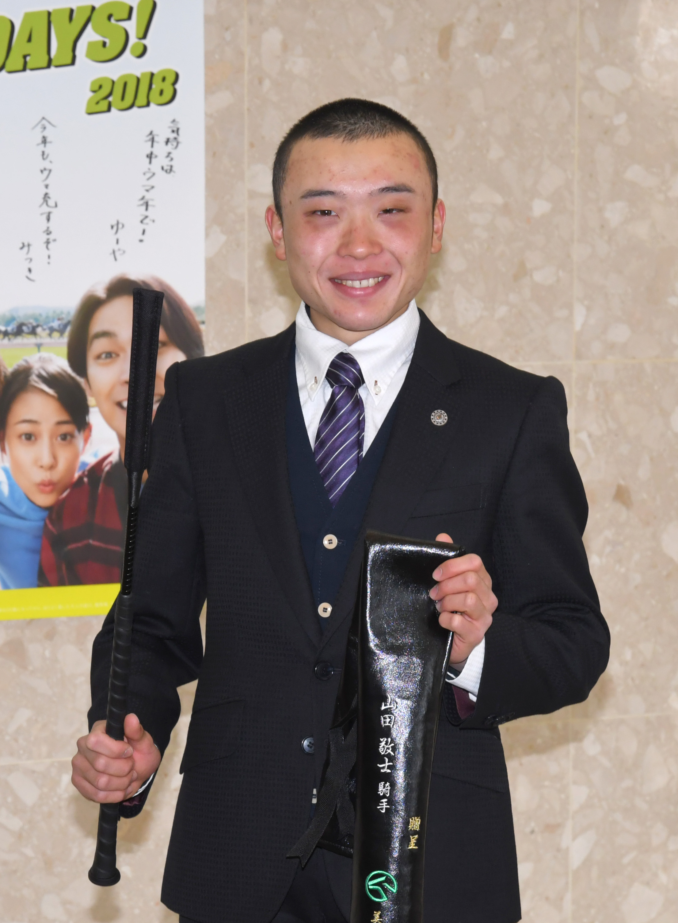 来週のデビューに向けて、記念のムチを贈呈される山田敬士騎手（撮影・酒井清司）