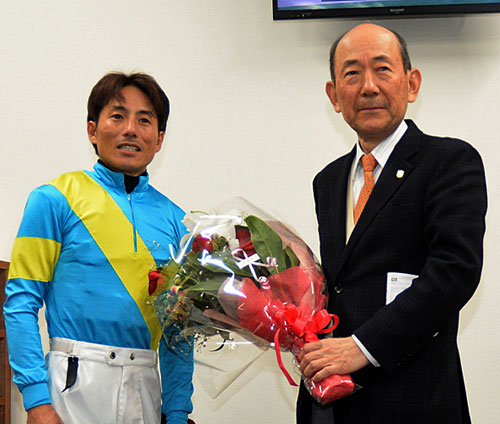１１Ｒ終了後、弟子の吉田豊騎手（左）から花束を贈られた大久保師（撮影・酒井清司）