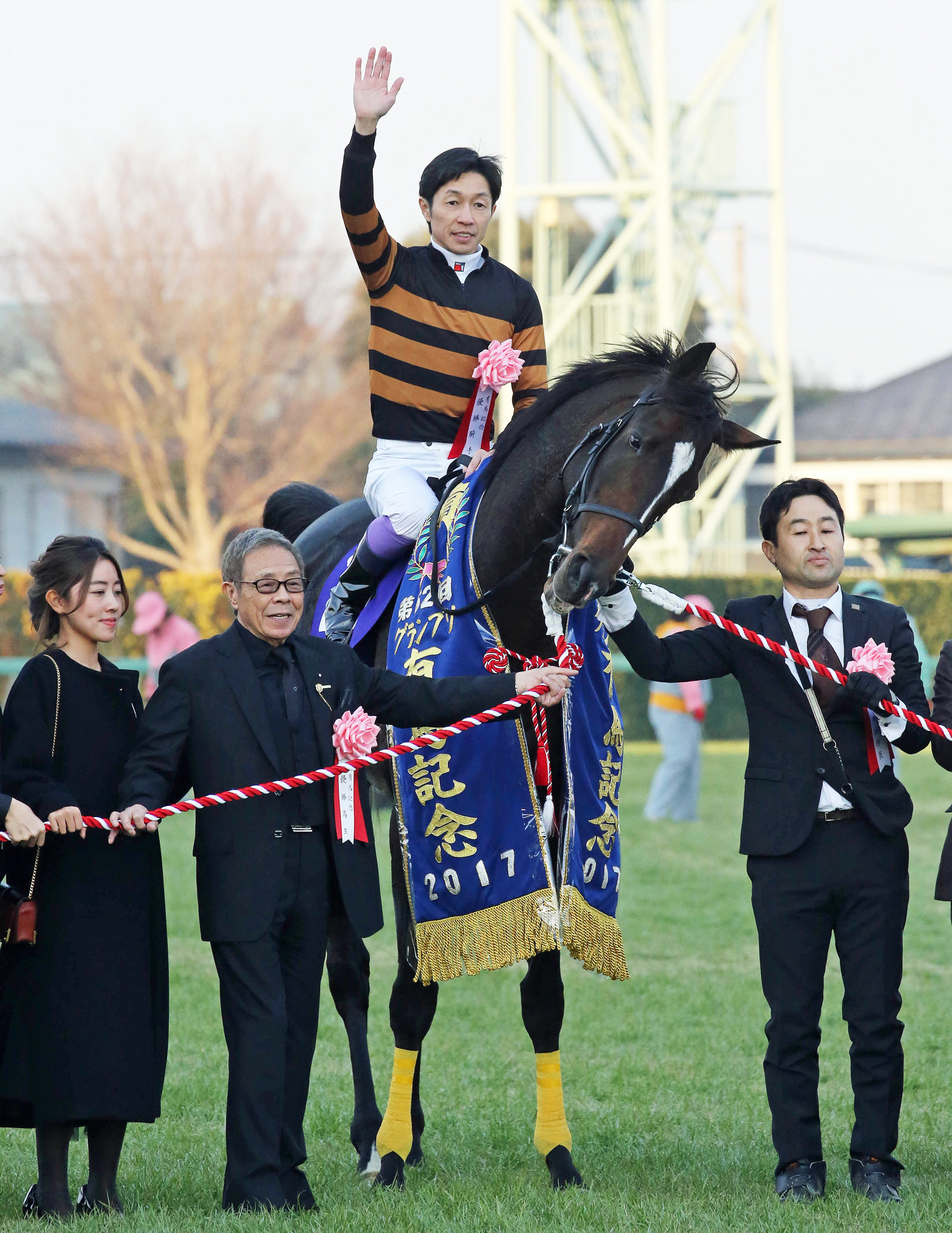 有馬記念を制したキタサンブラックの口取りで写真に納まる武豊騎手と北島三郎オーナー（撮影・丹羽敏通）