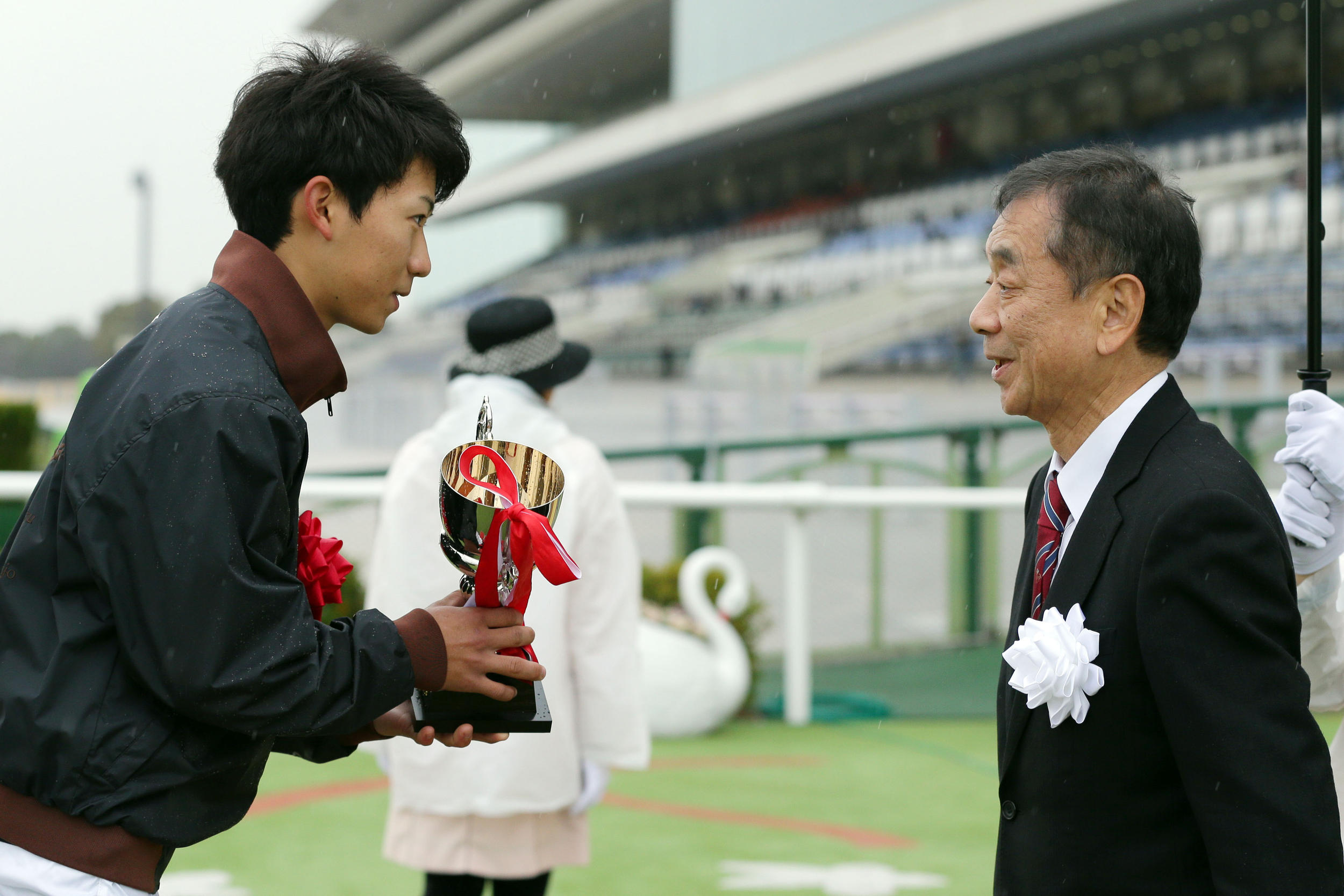 ホープ賞の表彰式で、日刊スポーツ新聞西日本・阿部社長（右）からカップを受け取る荻野騎手（撮影・前田充）