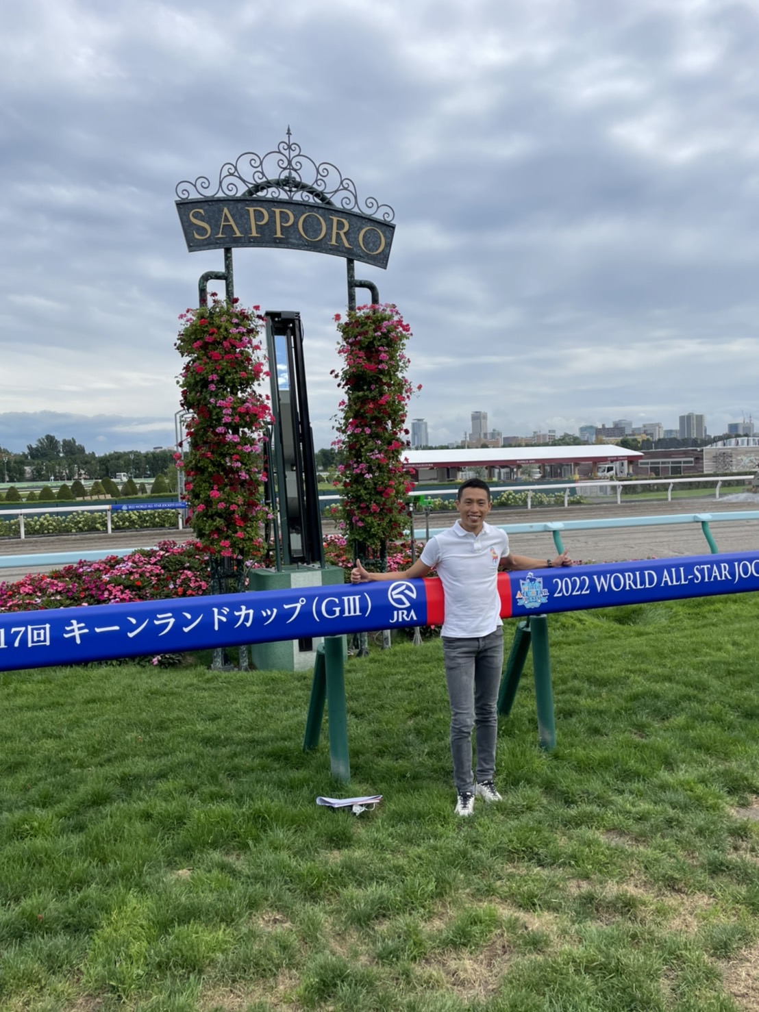 札幌競馬場の芝コースのゴール前で記念撮影するホー騎手